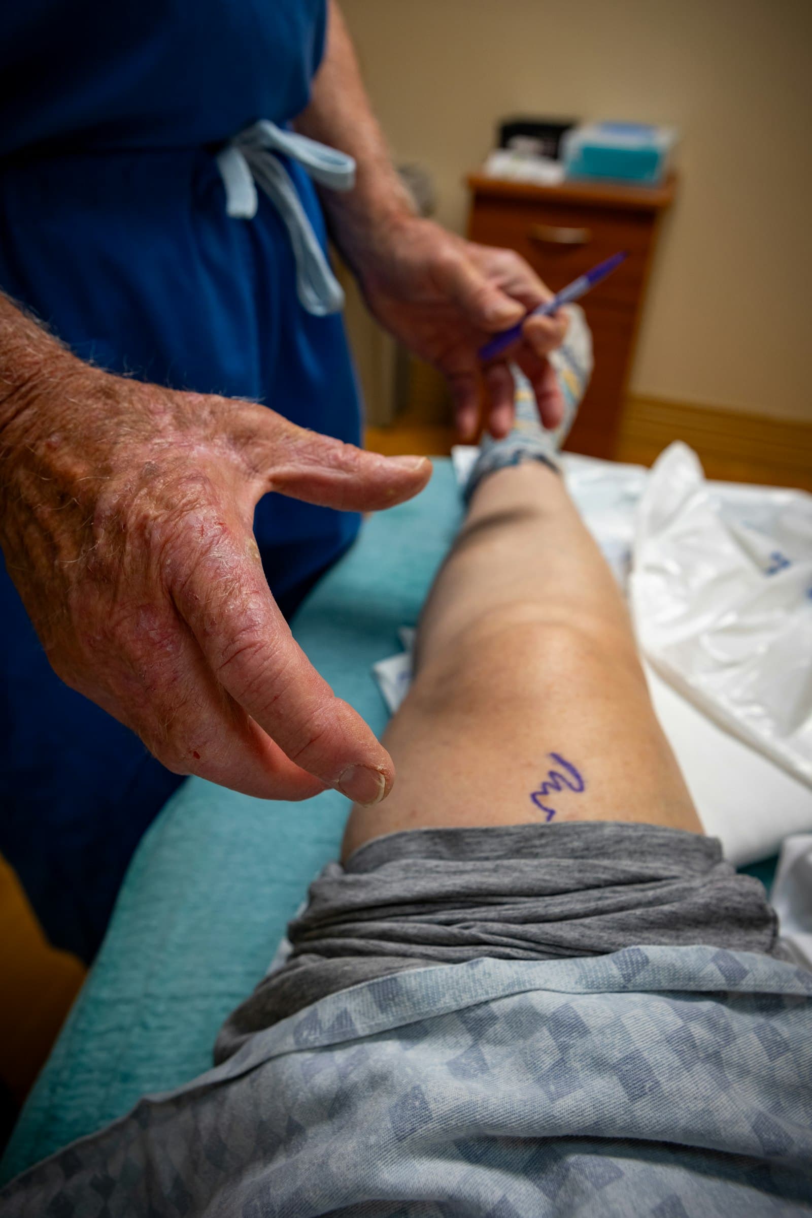 Patient doing heel slides after knee surgery, supported by a physiotherapist