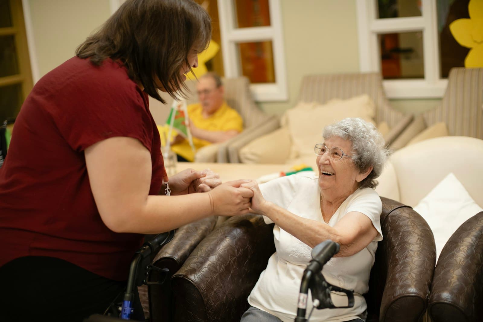 A physiotherapist guiding an older adult through an exercise at home